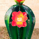 Close-up reveals the orange flowers and intricate detailing along the cactus edges.