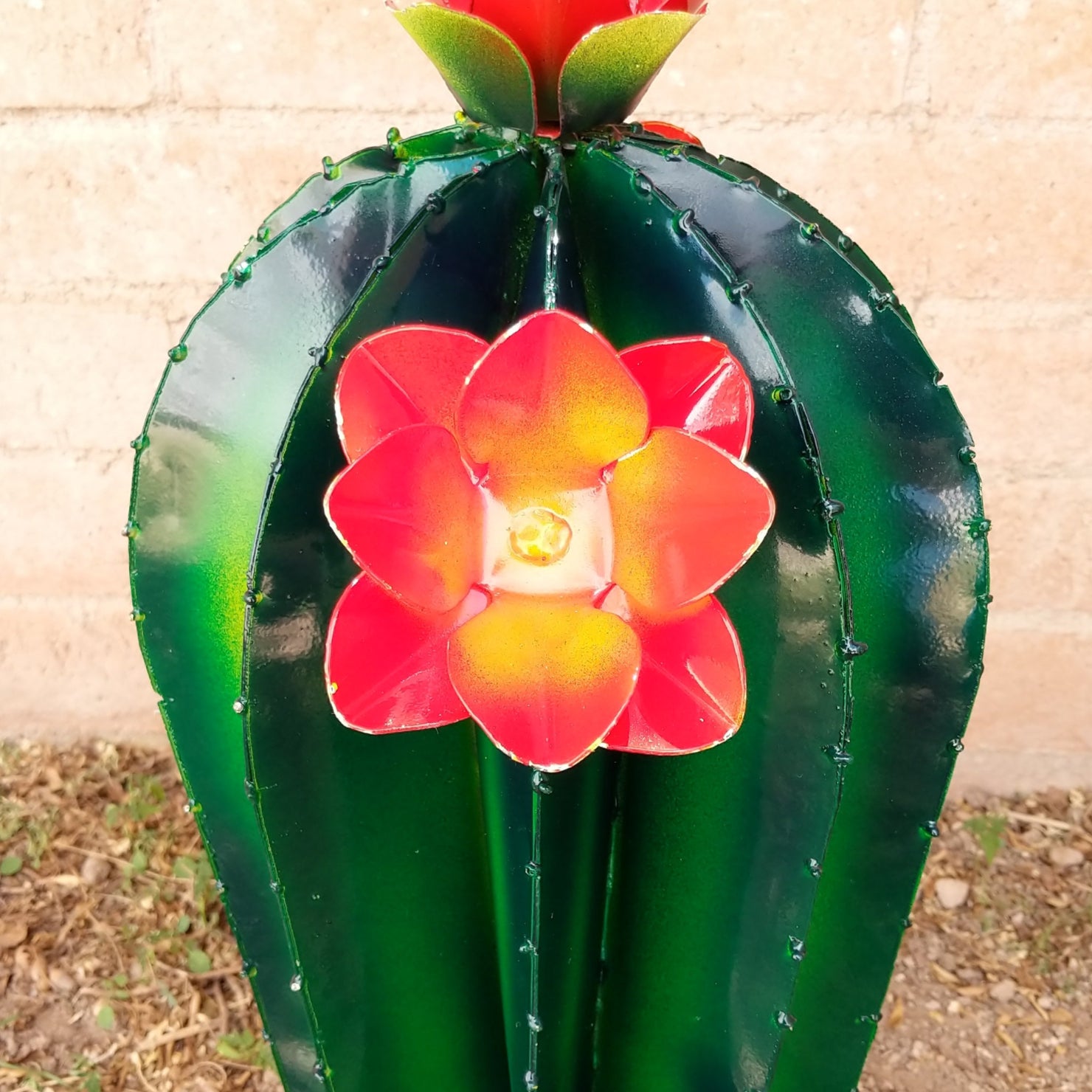 Close-up reveals the orange flowers and intricate detailing along the cactus edges.