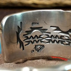 Spiderweb #8 turquoise cuff by Andrew Gordon, featuring an oval blue Spiderweb #8 turquoise stone with natural spiderweb matrix set in a handcrafted sterling silver cuff with hand-stamped fan and geometric designs; artisan and Sterling Silver stamp.