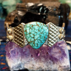 The front of the cuff featuring the Spiderweb Kingman Turquoise and intricate gold and silver cuff detailing.