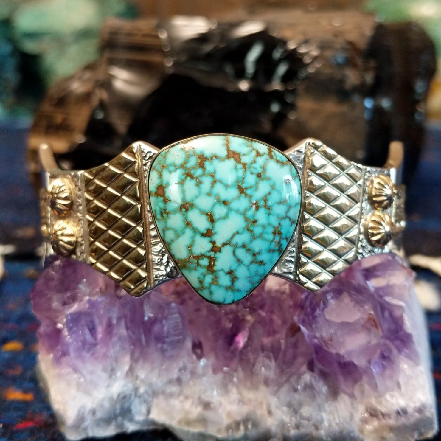 The front of the cuff featuring the Spiderweb Kingman Turquoise and intricate gold and silver cuff detailing.