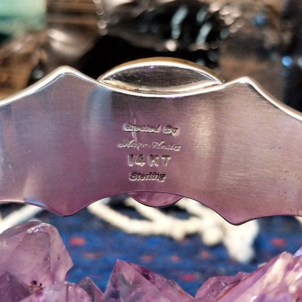 The artist's signature and authentication stamp are found on the inside of the cuff.