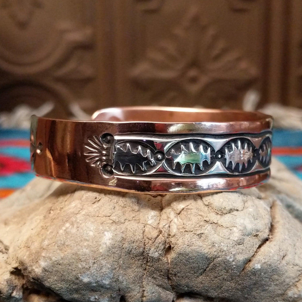 Copper and sterling silver cuff with spine oval stamping on the silver.