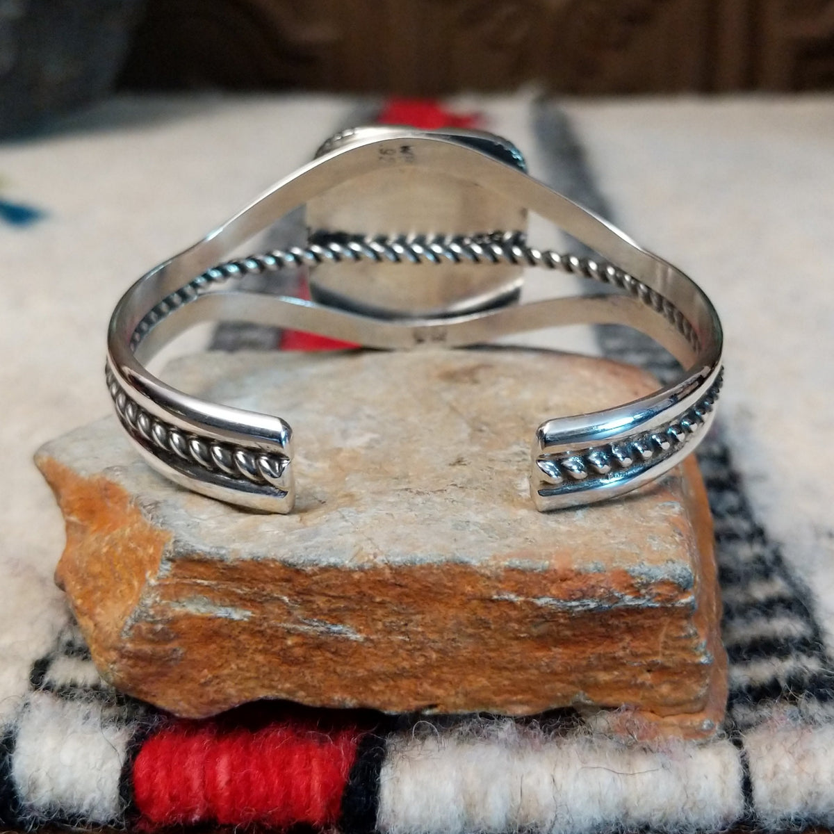 Silver cuff by Walter Vandever featuring a large square Kingman turquoise stone with brown matrix, framed by detailed silverwork and a split-band design with a twisted center strand; underside view.
