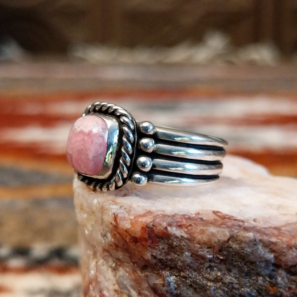 Square rhodochrosite framed by the twisted rope, with a dotted and layered band of the ring.