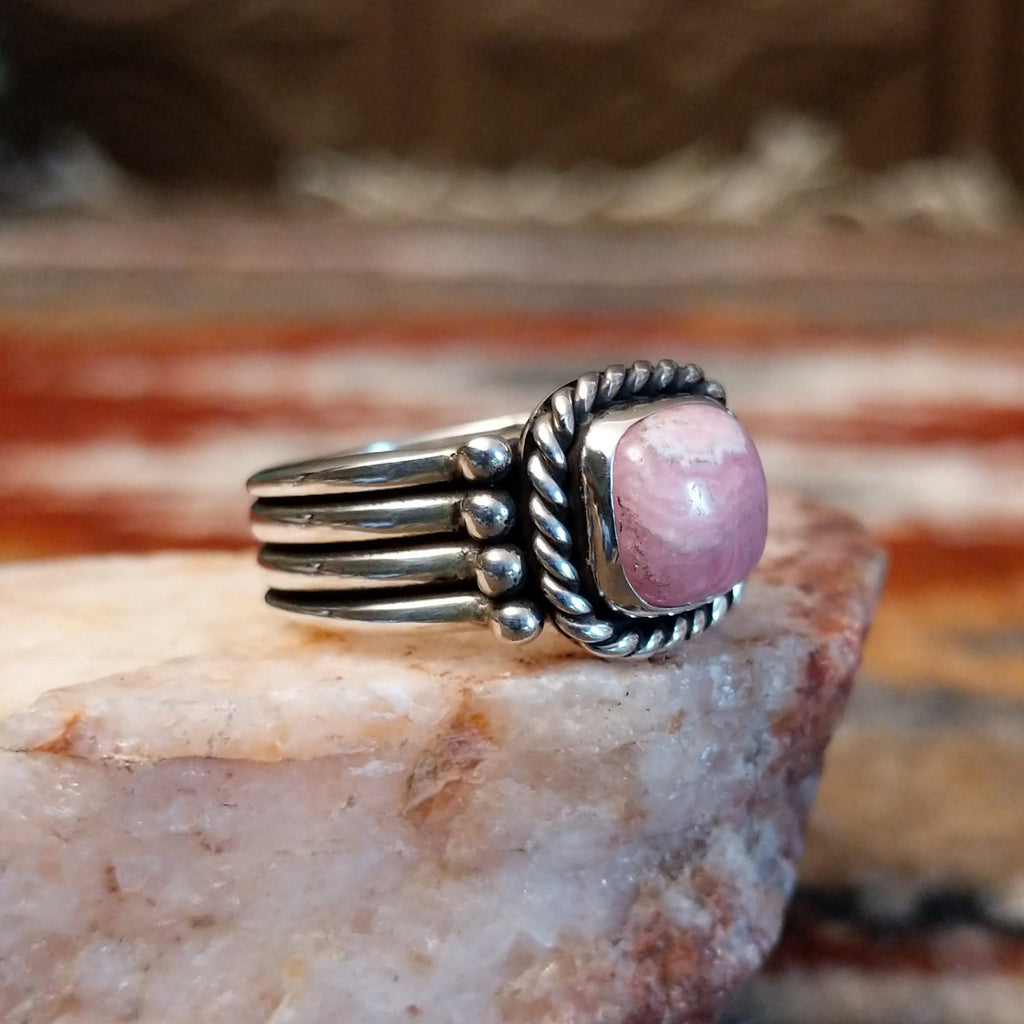 Square rhodochrosite framed by the twisted rope, with a dotted and layered band of the ring.