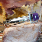 Sugilite set within the square bezel of of the polished silver cuff.