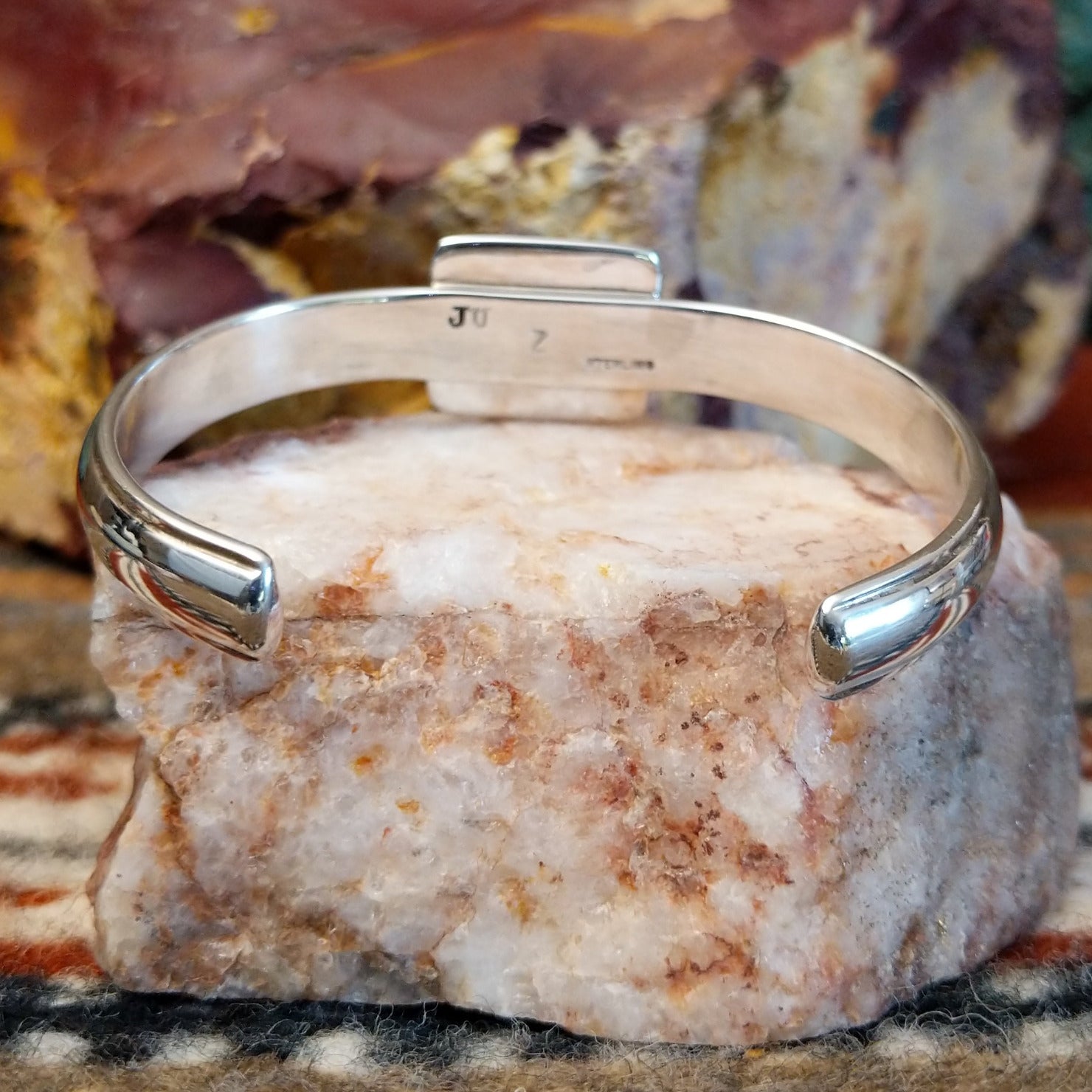 Sugilite set within the square bezel of of the polished silver cuff.