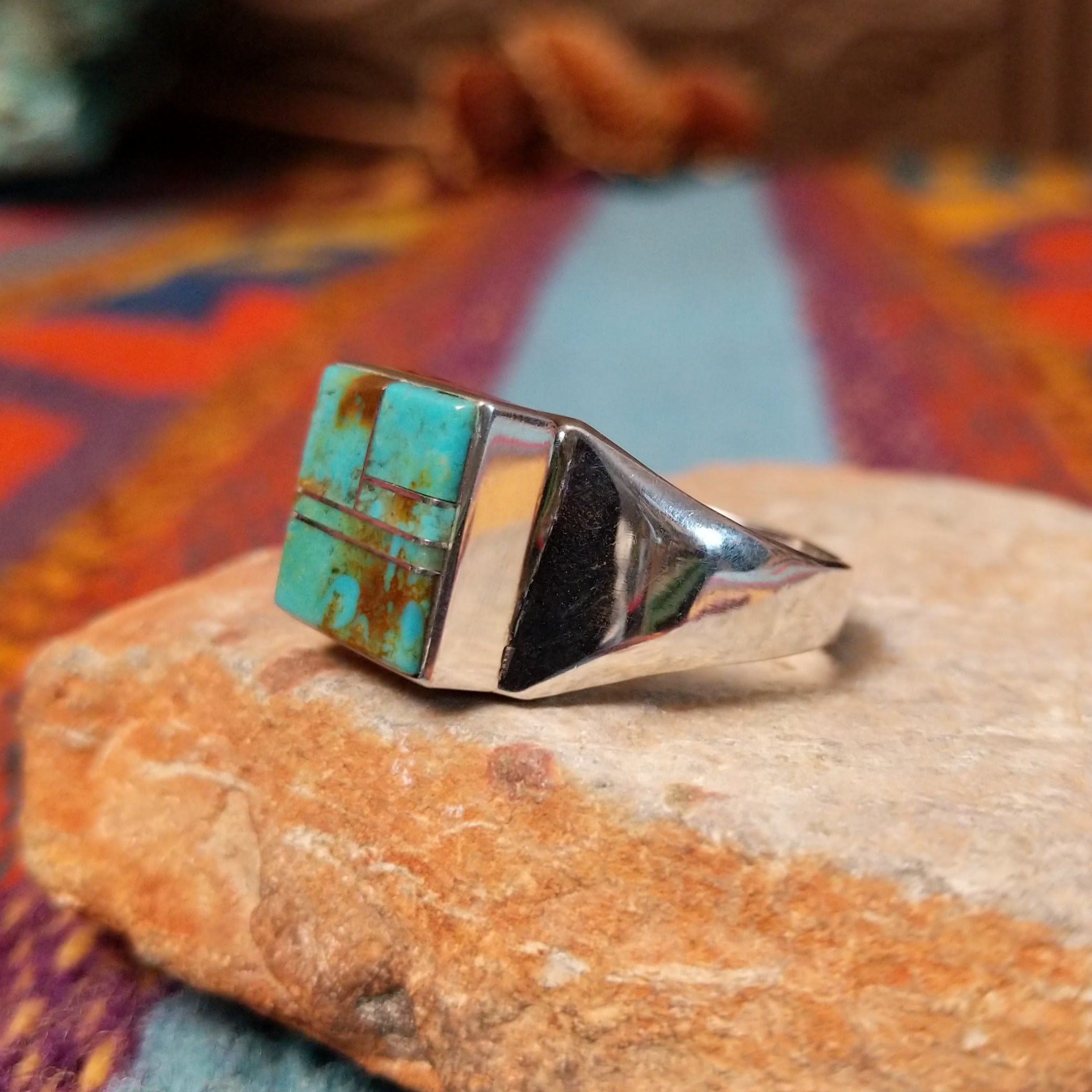 Square Turquoise Inlay Ring by Wilbert Grey featuring geometric turquoise inlay with natural brown matrix, separated by Sterling Silver channels and set on a polished silver band; side view.