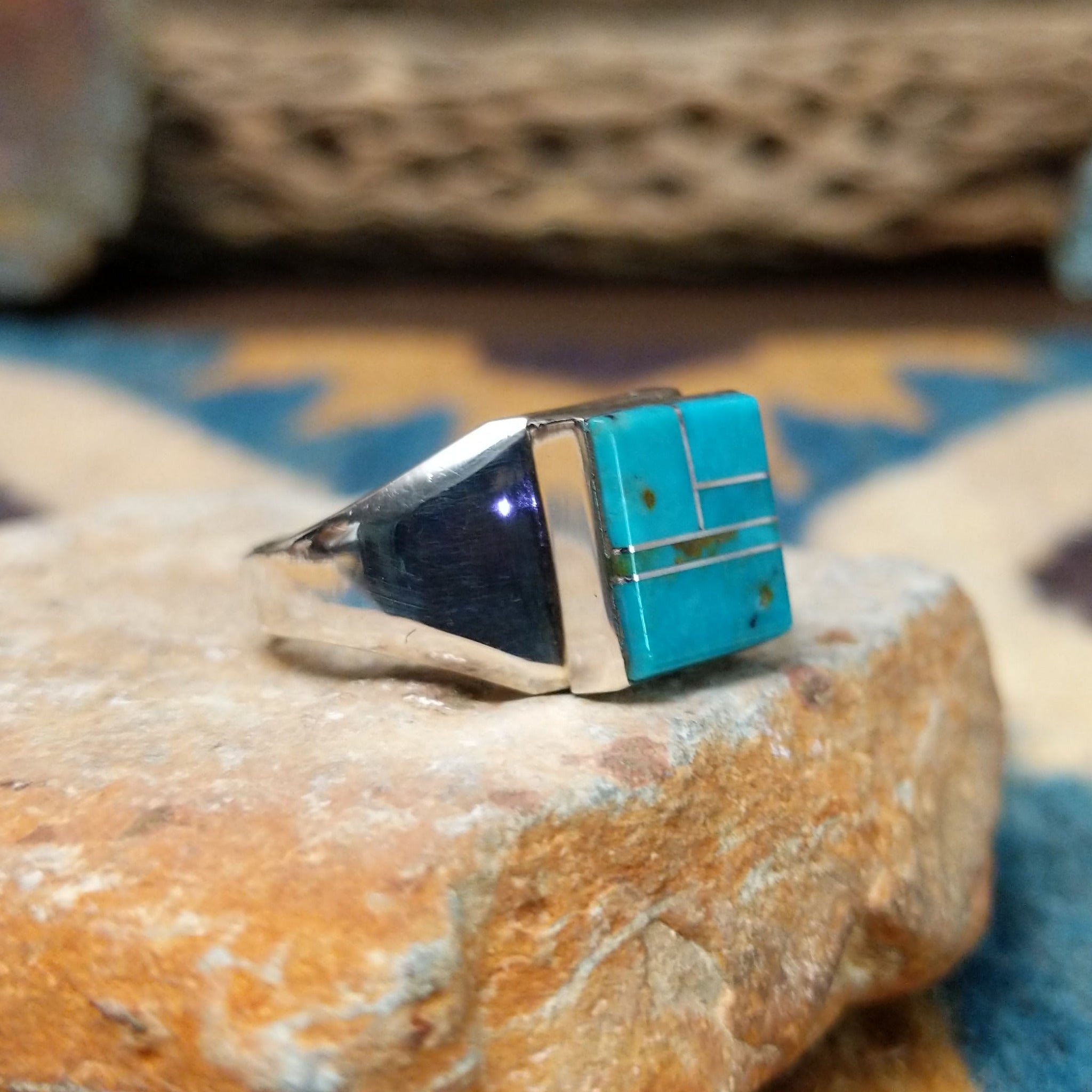 Handcrafted Navajo sterling silver ring by Wilbert Grey featuring a square turquoise inlay with sterling silver channel accents in a polished geometric setting; side view.