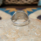 Handcrafted Navajo sterling silver ring by Wilbert Grey featuring a square turquoise inlay with sterling silver channel accents in a polished geometric setting; underside view.