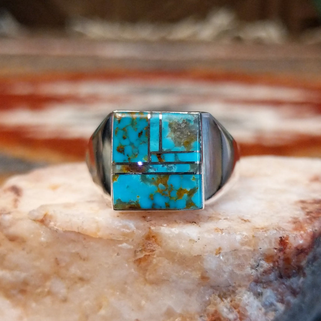Rectangular turquoise inlaid in the bezel of the sterling silver ring.
