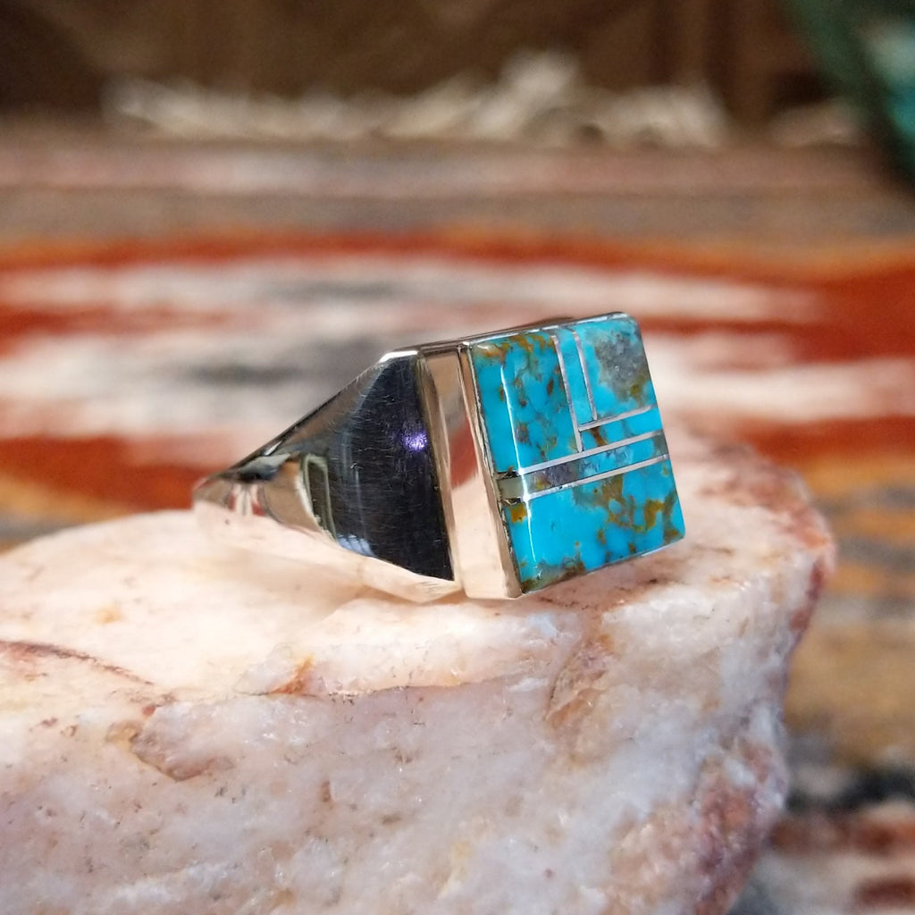 Rectangular turquoise inlaid in the bezel of the sterling silver ring.