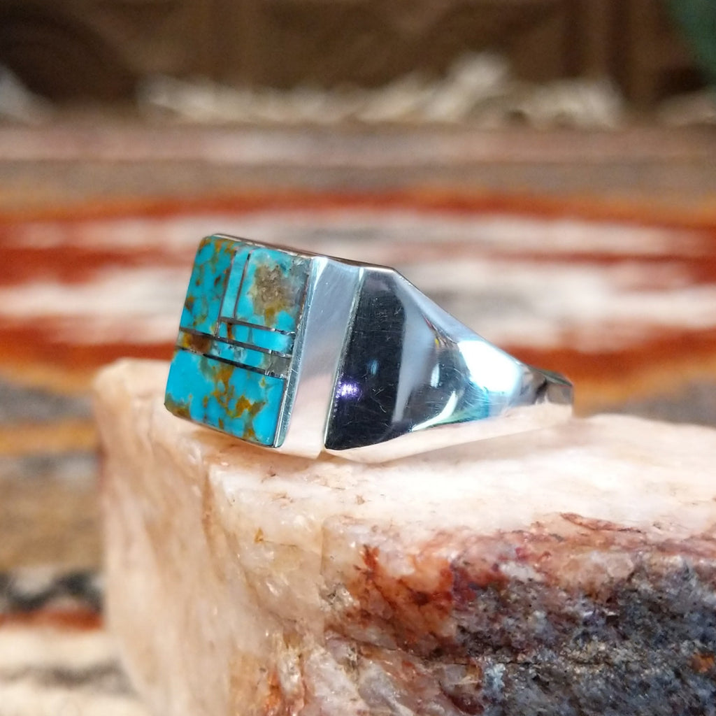 Rectangular turquoise inlaid in the bezel of the sterling silver ring.