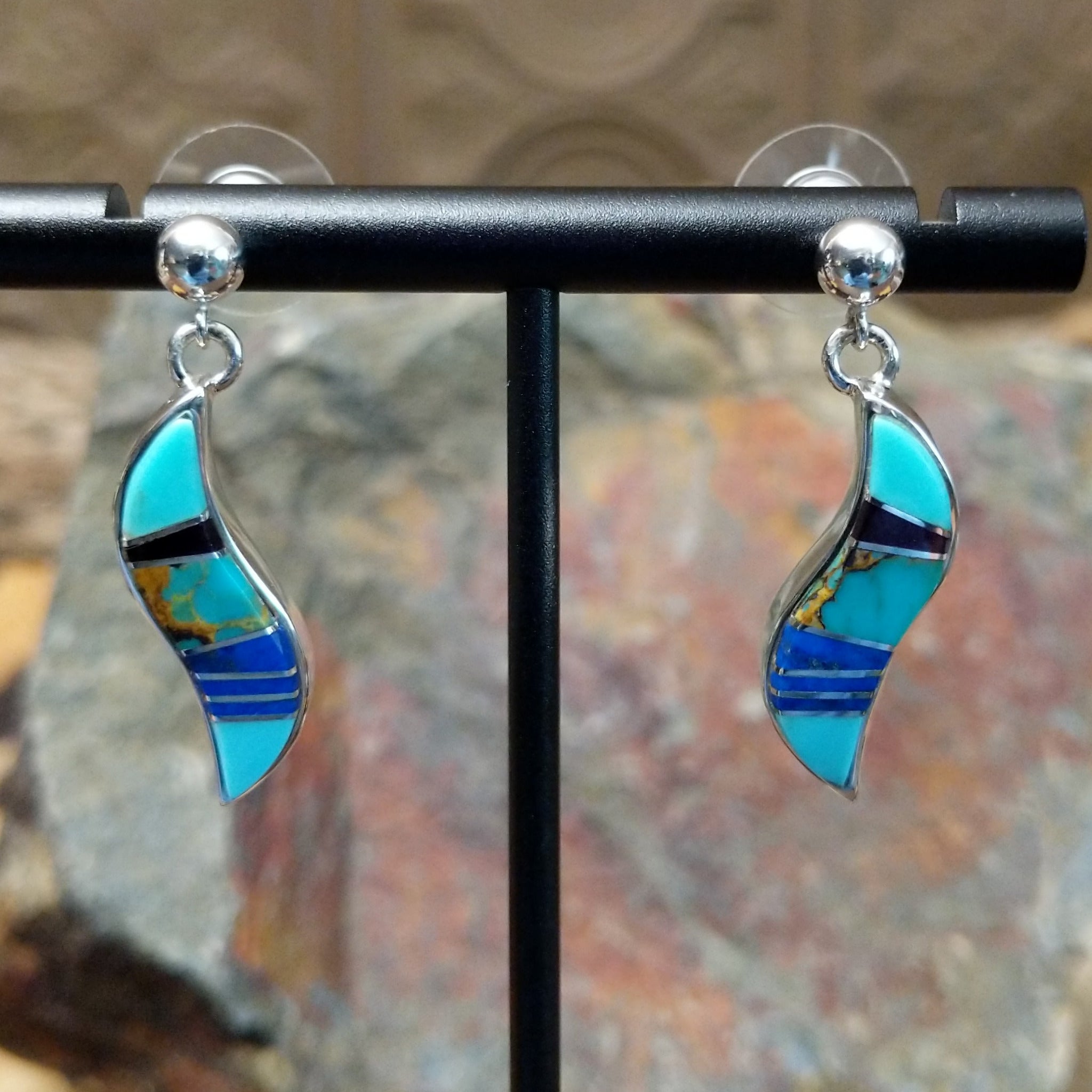 Handcrafted sterling silver inlay earrings by O. James, featuring a curved design with colorful multistone inlay.