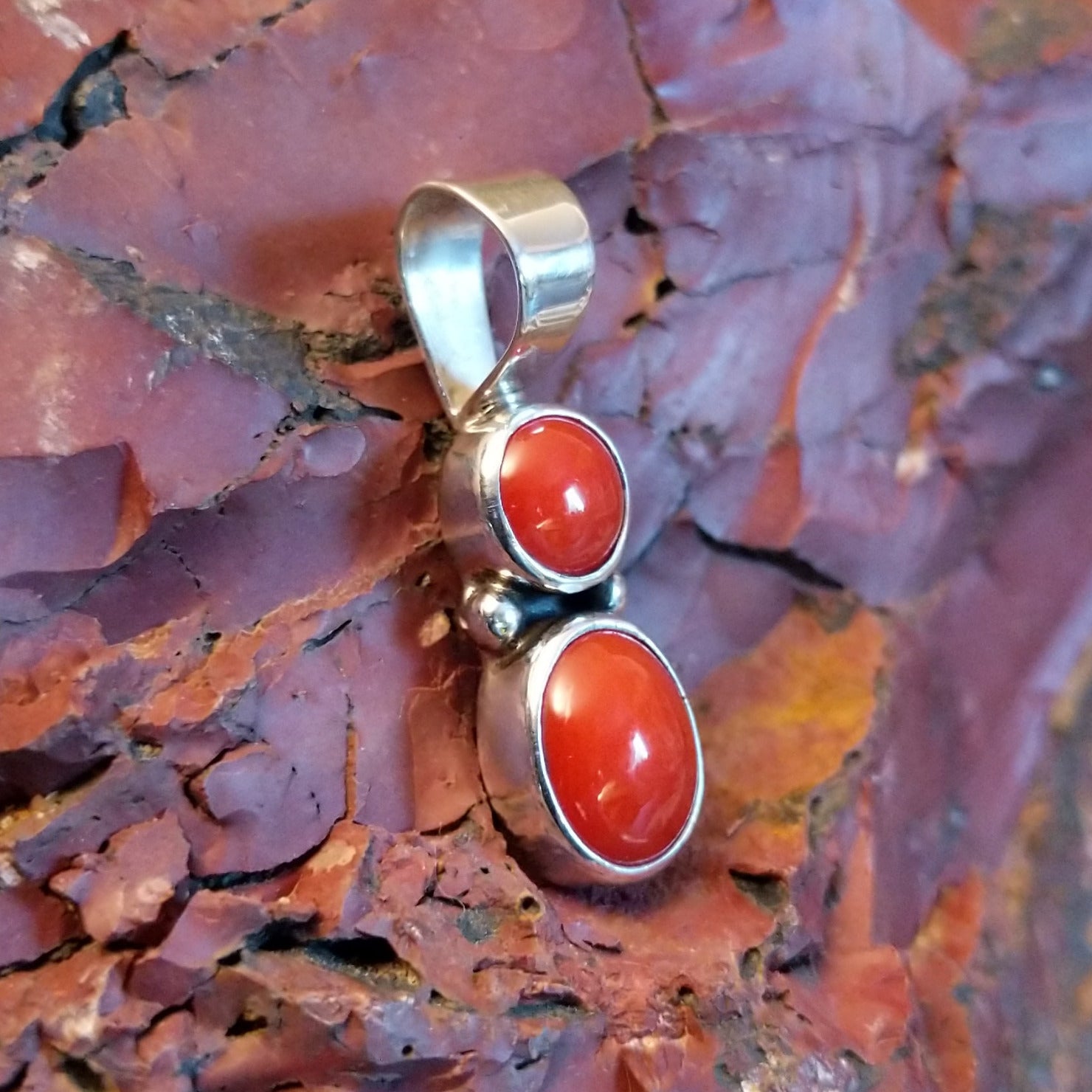 Sterling silver pendant with coral set in the two bezels.