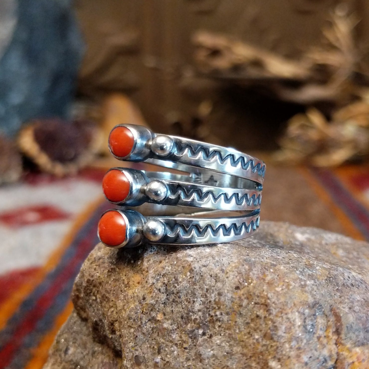 Stacked sterling silver ring with coral set in three oval bezels and stamping on the bands.