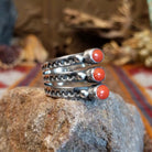 Stacked sterling silver ring with coral set in three oval bezels and stamping on the bands.