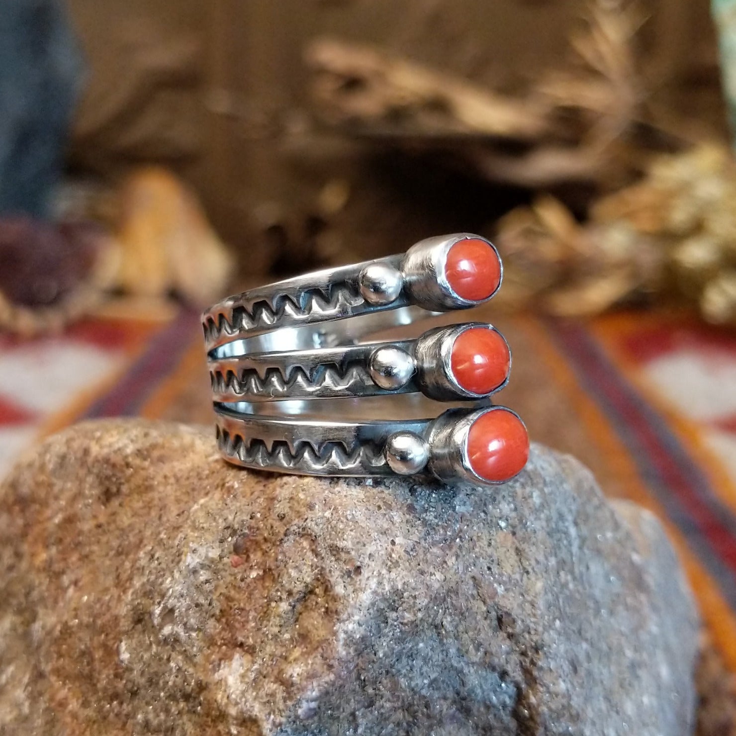 Stacked sterling silver ring with coral set in three oval bezels and stamping on the bands.