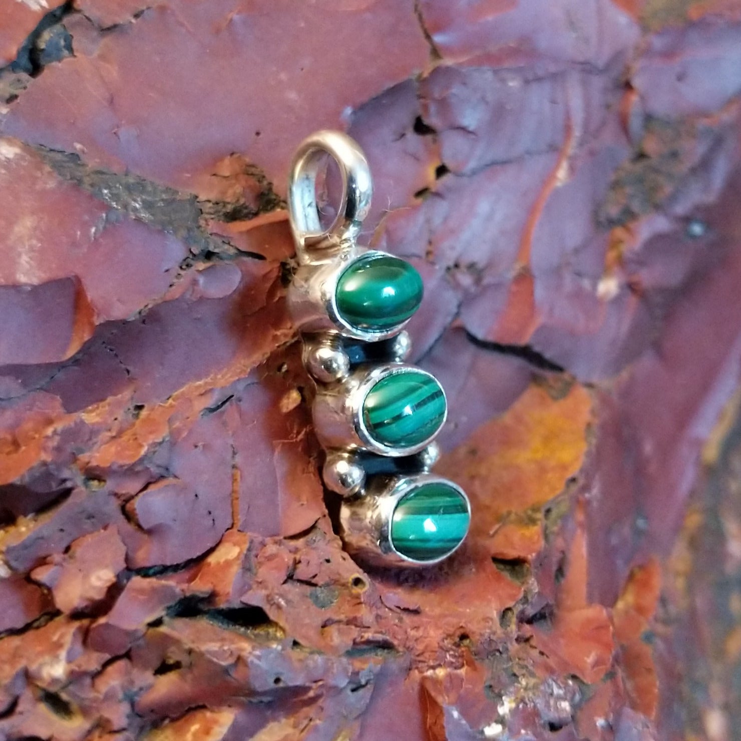 Stacked pendant with malachite set within the bezels.
