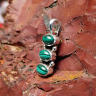 Stacked pendant with malachite set within the bezels.
