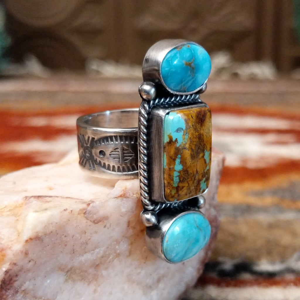 Stacked sterling silver ring of sonoran gold turquoise and boulder turquoise featuring twisted rope and dotted accents.