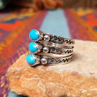 Stacked Turquoise Ring by Raymond Coriz featuring three oval turquoise stones set across three Sterling Silver bands with polished silver beads and hand-stamped detailing; side view.