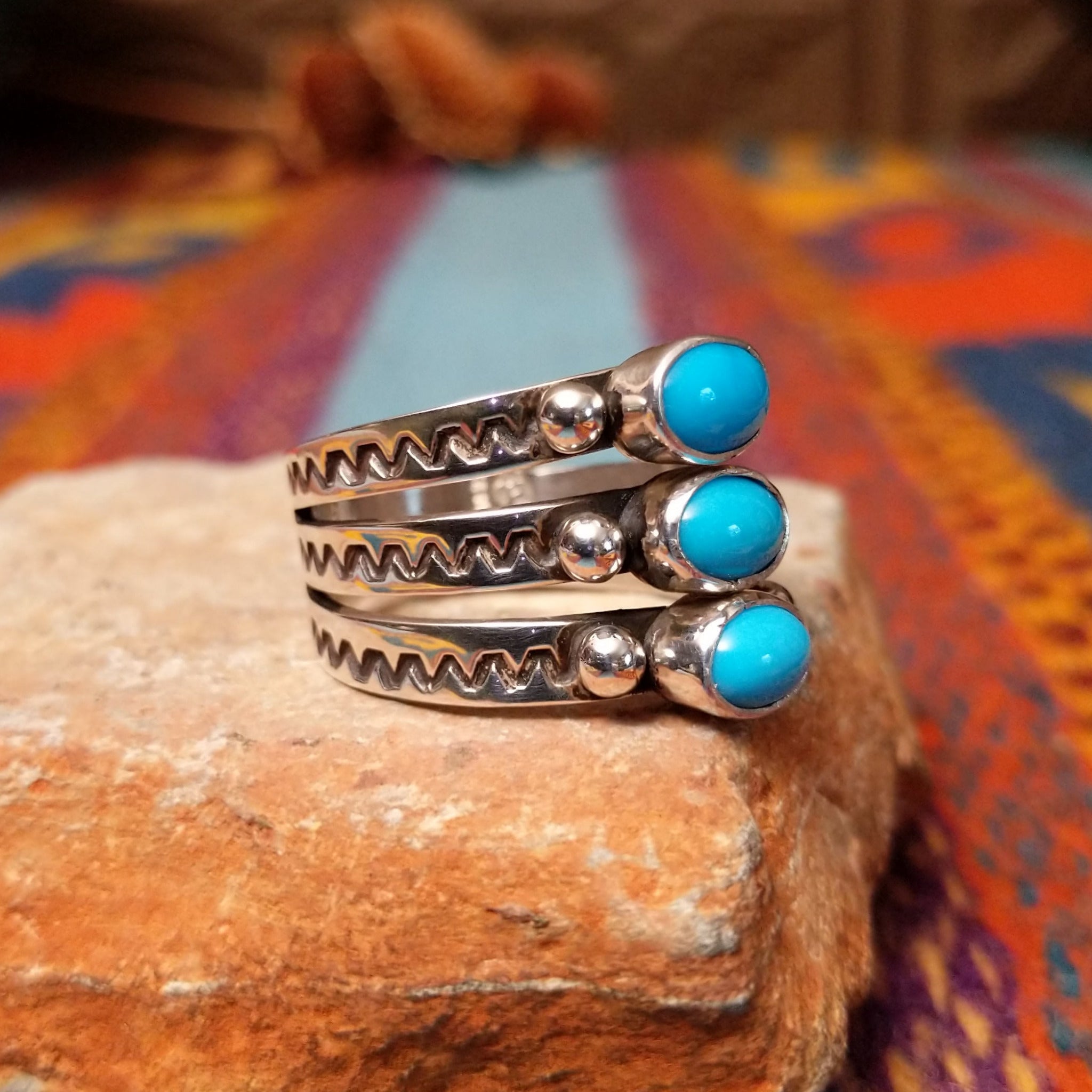 Stacked Turquoise Ring by Raymond Coriz featuring three oval turquoise stones set across three Sterling Silver bands with polished silver beads and hand-stamped detailing; side view.