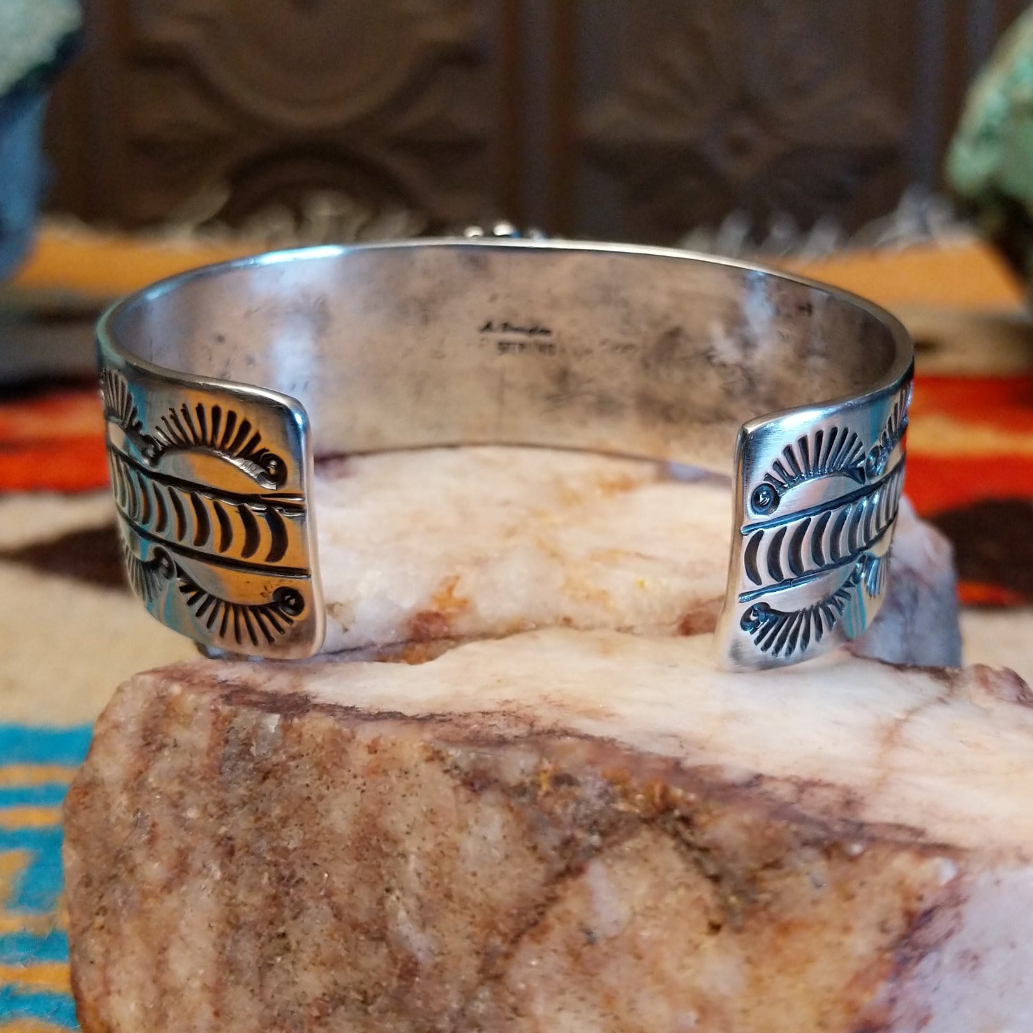 Sterling silver cuff bracelet with Kingman turquoise set in the oval bezel, framed by twisted rope, dotted accents, and stamped designs on the band.