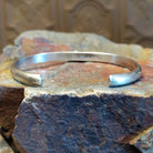 Sterling silver cuff bracelet with intricate stamping along the band and lapis set in the round bezel.
