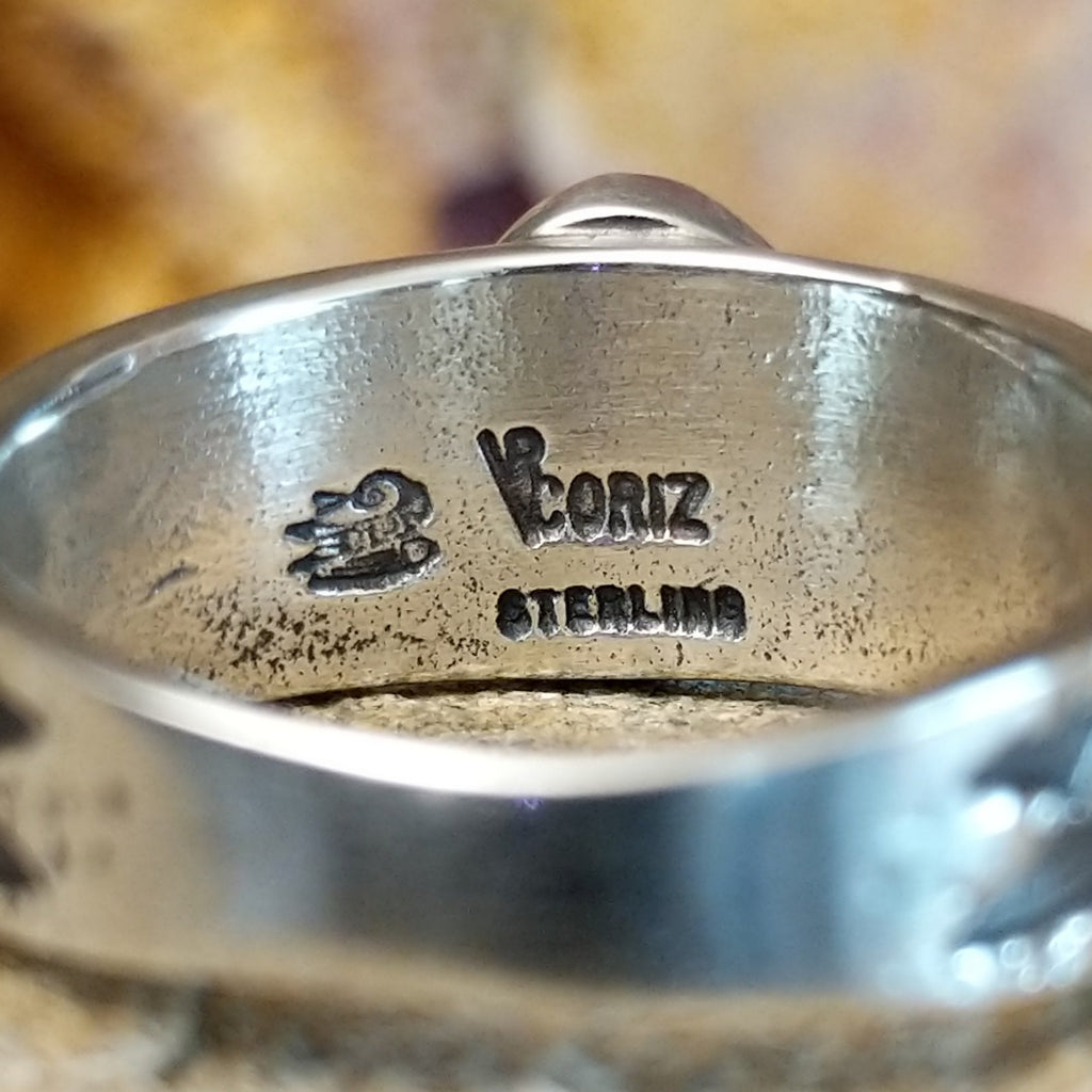 The artisan's signature is stamped on the underside of the band.