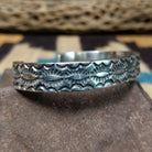 Stamped sterling silver cuff by B. Shorty, featuring intricate hand-stamped geometric and floral-inspired patterns on a handcrafted open sterling silver cuff.