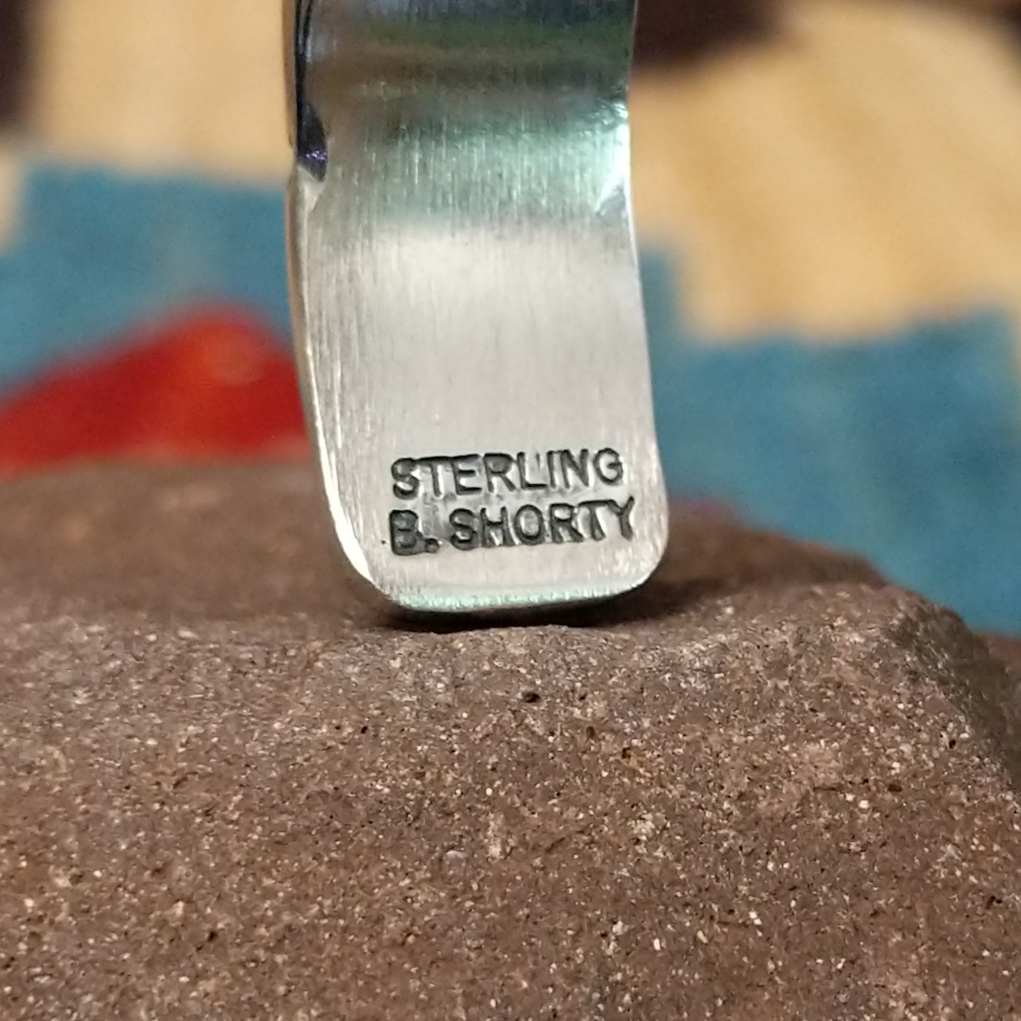 Stamped sterling silver cuff by B. Shorty, featuring intricate hand-stamped geometric and floral-inspired patterns on a handcrafted open sterling silver cuff.  Artisan and Sterling Silver stamp.