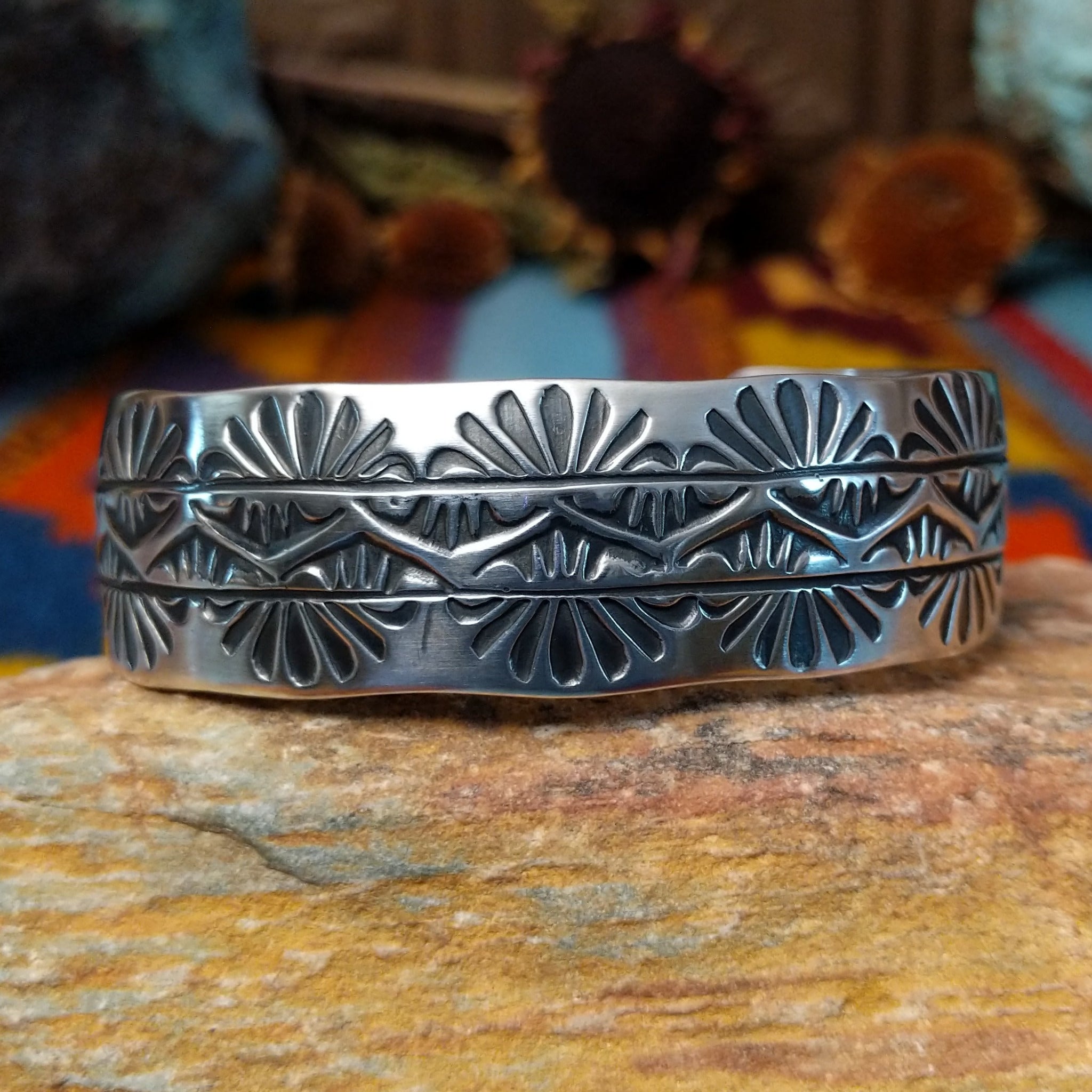 Wide silver cuff by Charlene Robert Little with three rows of repeating fan and geometric stampwork.
