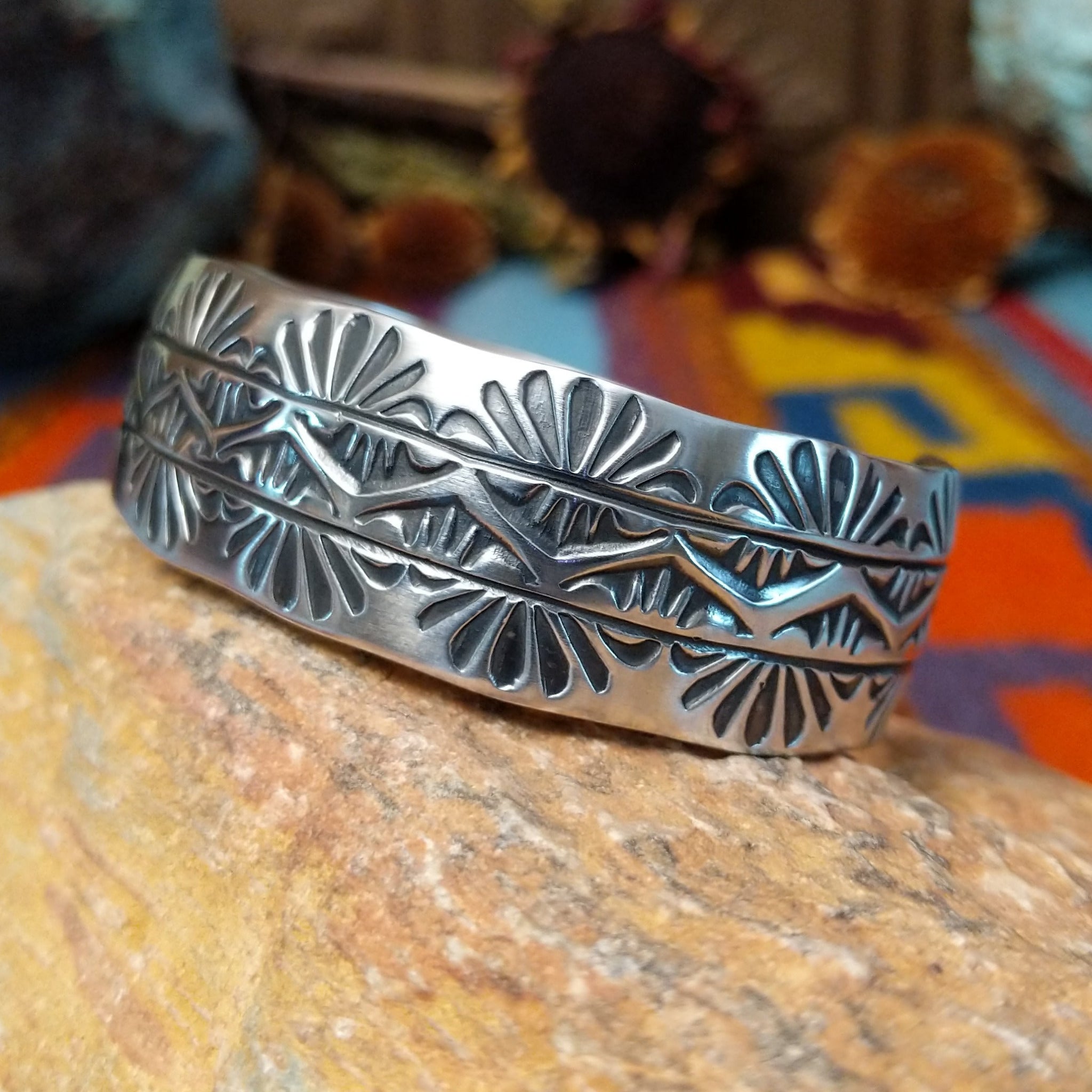 Wide silver cuff by Charlene Robert Little with three rows of repeating fan and geometric stampwork.