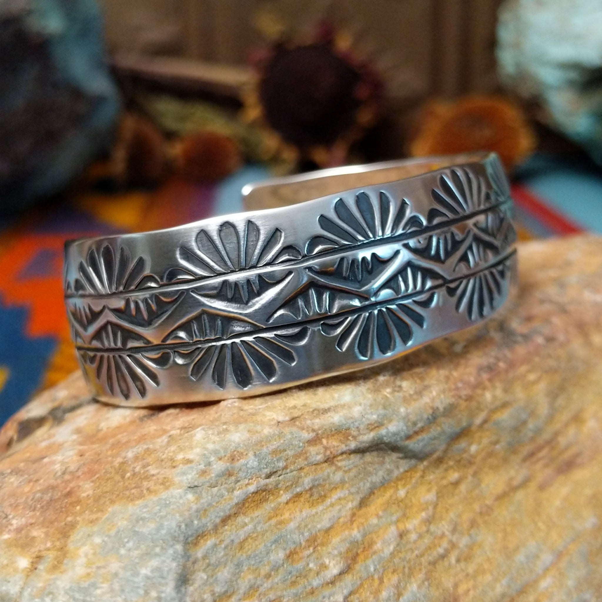 Wide silver cuff by Charlene Robert Little with three rows of repeating fan and geometric stampwork.