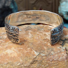 Wide silver cuff by Charlene Robert Little with three rows of repeating fan and geometric stampwork.