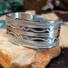 Stamped sterling silver cuff by Gilbert Begay, featuring intricate hand-stamped patterns, a polished finish, and handcrafted Southwestern-inspired design.