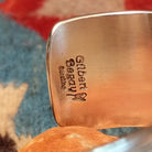 Stamped sterling silver cuff by Gilbert Begay, featuring intricate hand-stamped patterns, a polished finish, and handcrafted Southwestern-inspired design.  Artisan and Sterling Silver stamp.