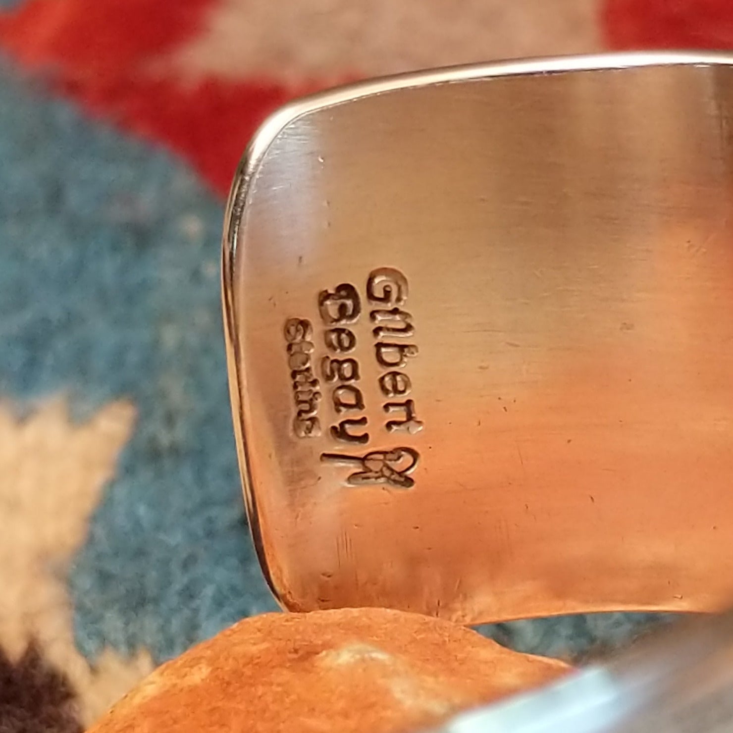 Stamped sterling silver cuff by Gilbert Begay, featuring intricate hand-stamped patterns, a polished finish, and handcrafted Southwestern-inspired design.  Artisan and Sterling Silver stamp.