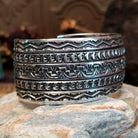 Wide sterling silver cuff bracelet with hand-stamped geometric and crescent motifs.