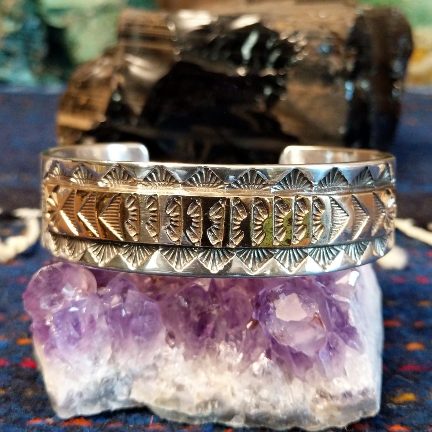Front shows the stamped silver and gold cuff with geometric patterns.