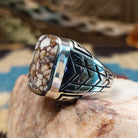 Sterling silver ring with wild horse stone set in the rectangular bezel and geometric stamping on the band.