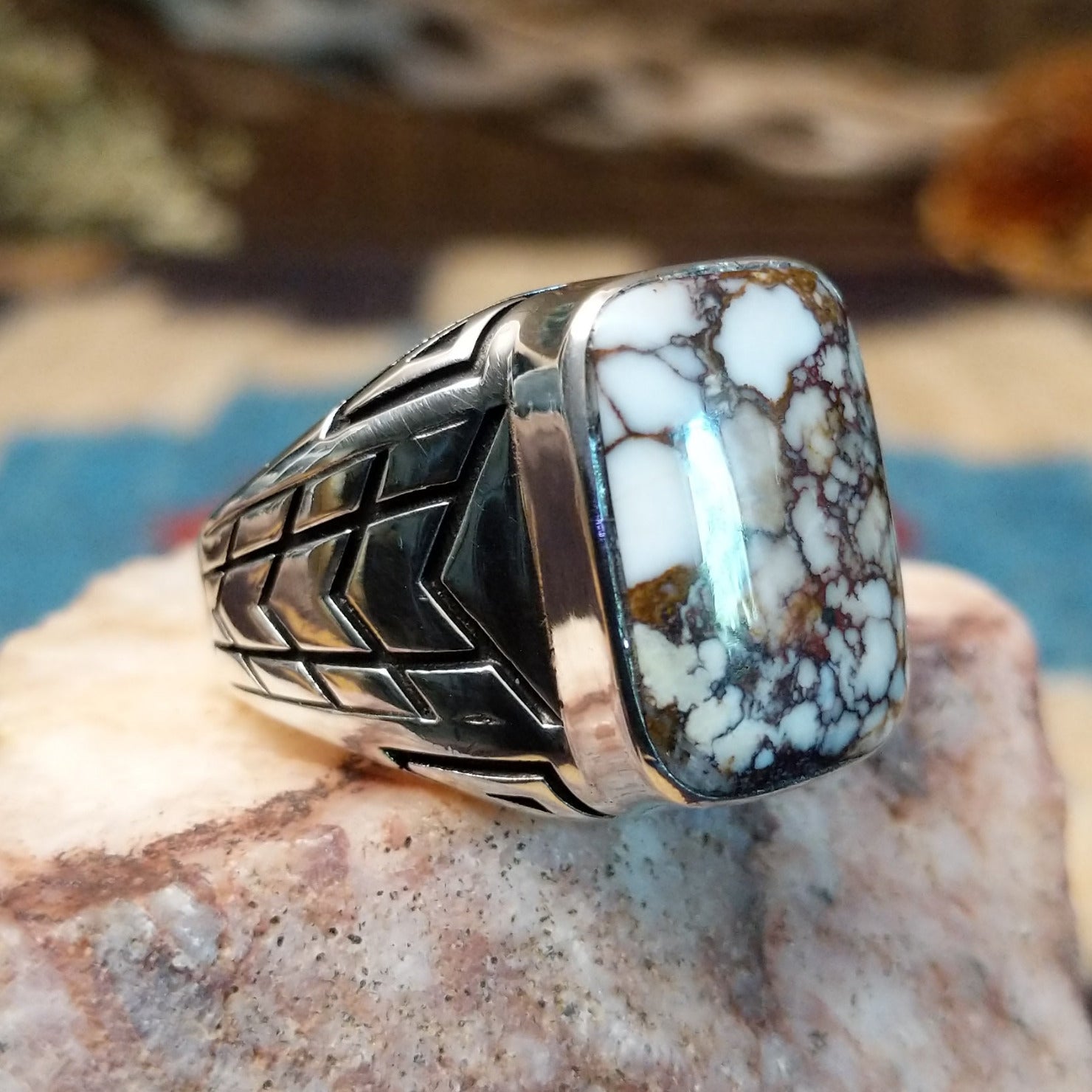 Sterling silver ring with wild horse stone set in the rectangular bezel and geometric stamping on the band.
