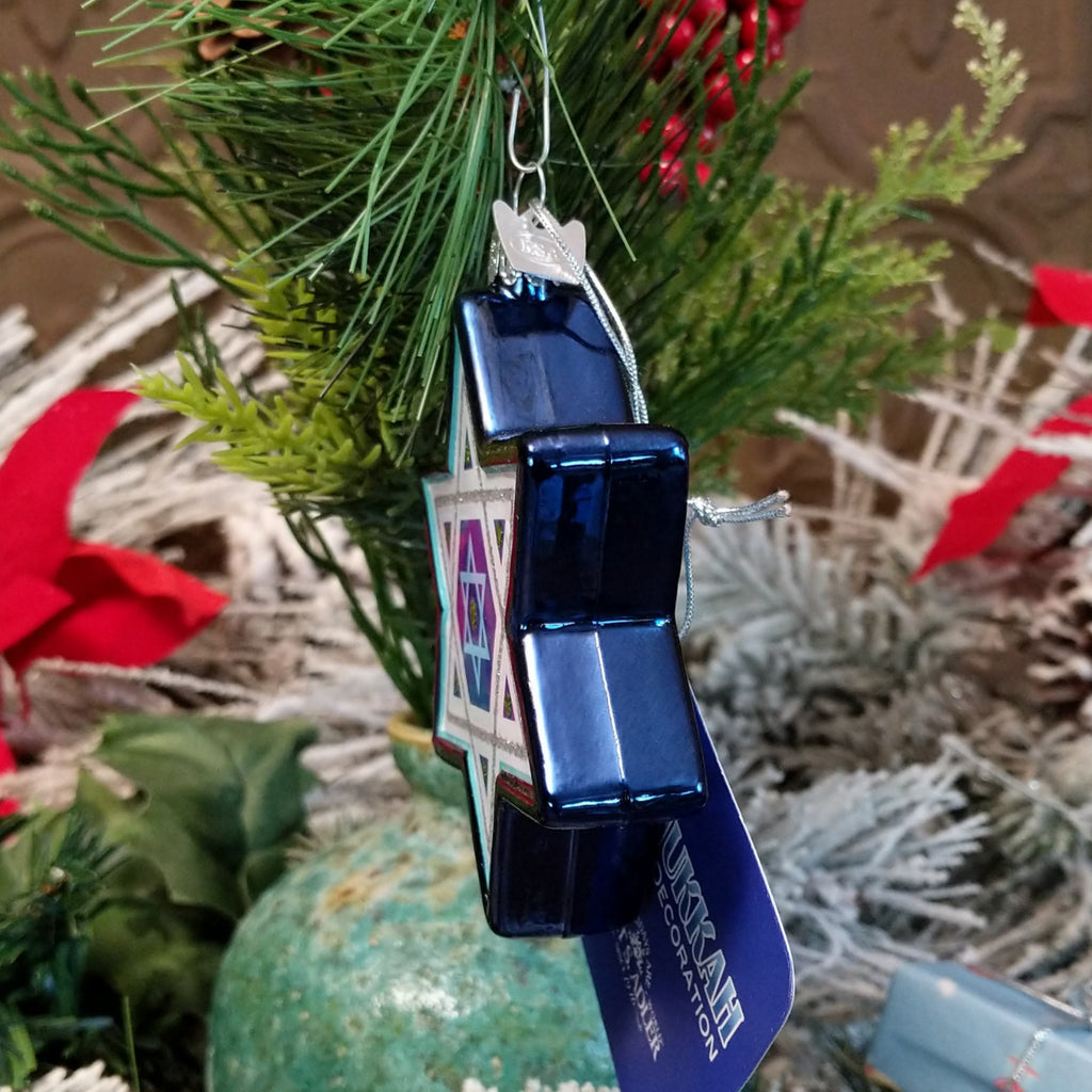 Glass made into the Star of David ornament in blue, white, and silver hues.