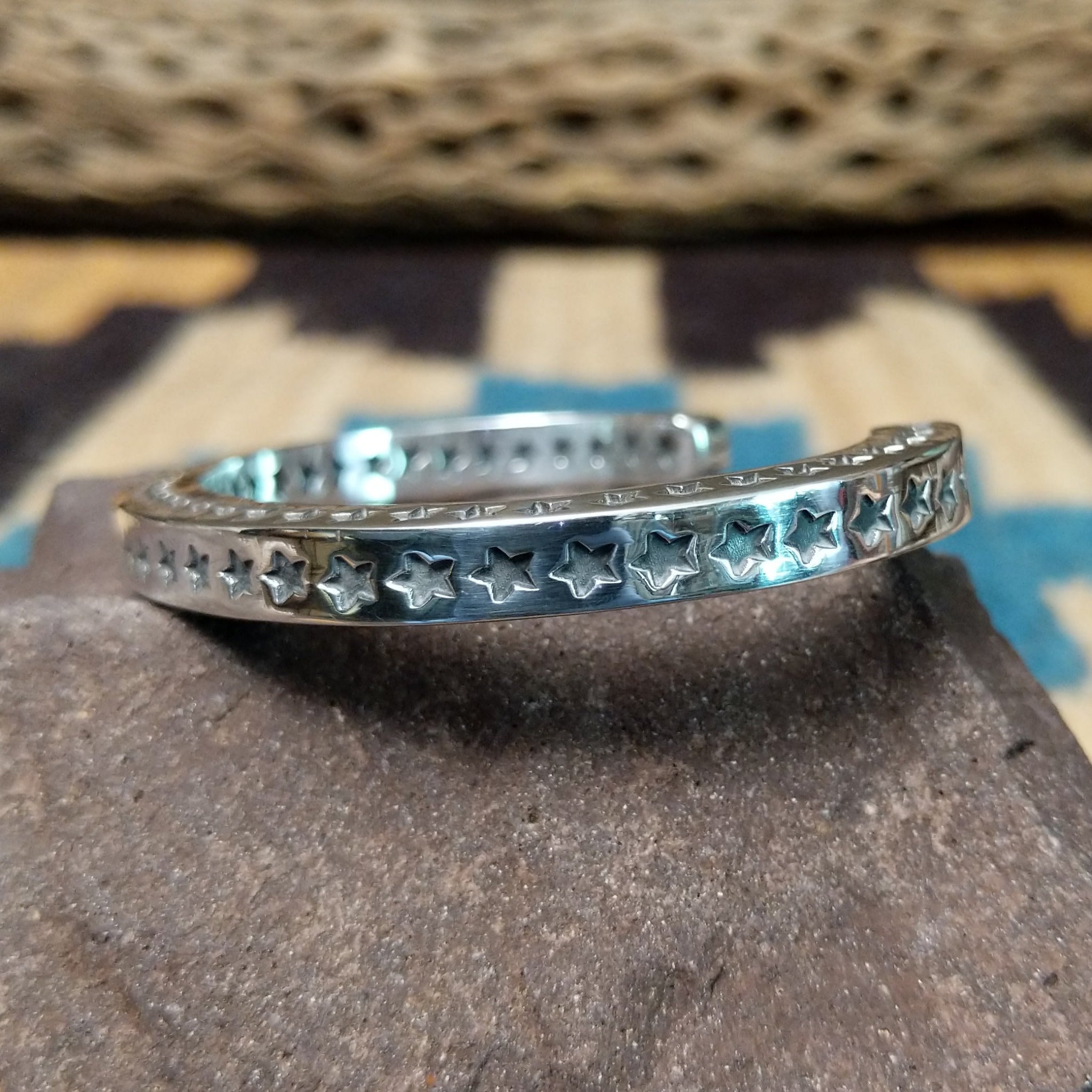 Starred sterling silver cuff by Sunshine Reeves, featuring hand-stamped star motifs and intricate geometric patterns on a handcrafted open sterling silver cuff.