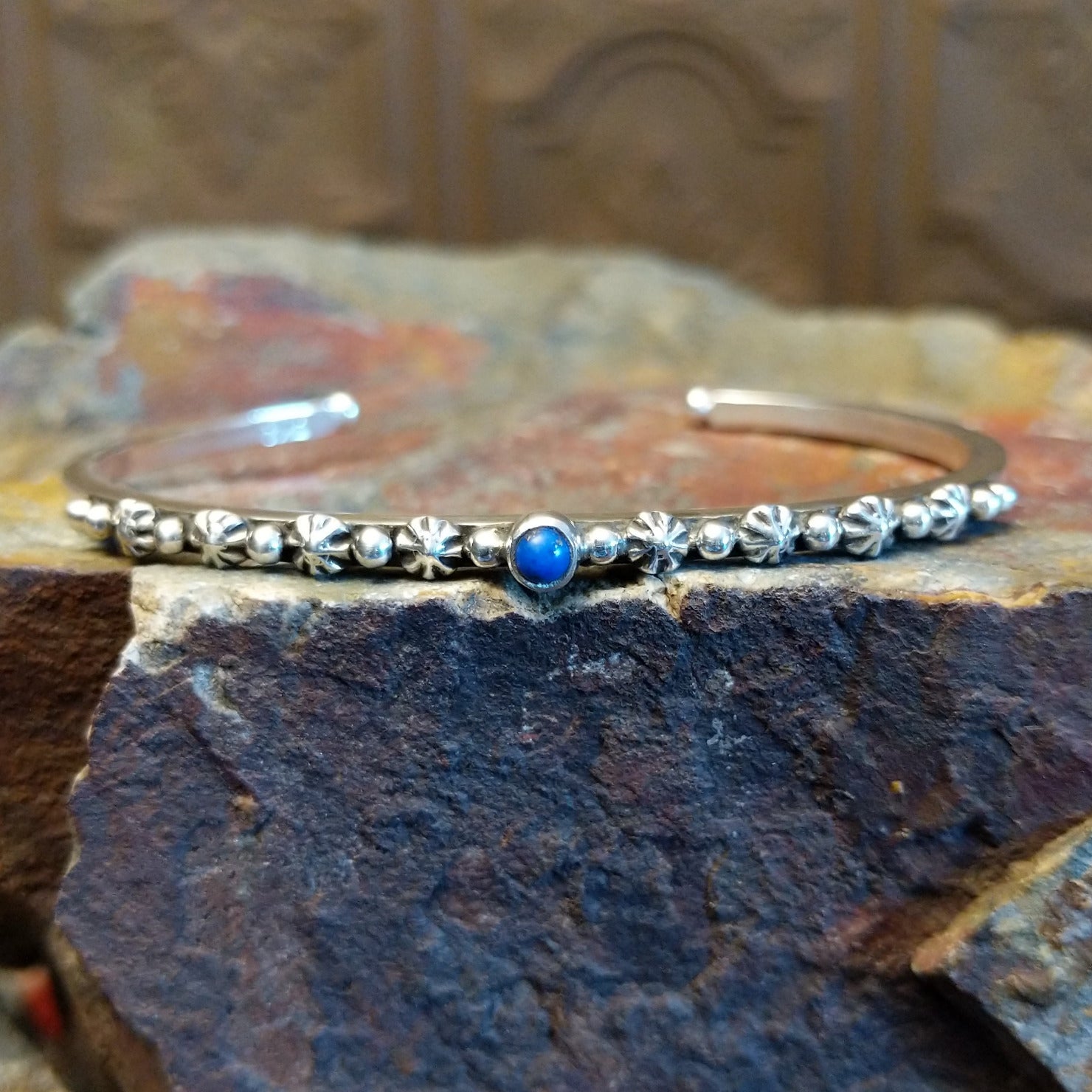Sterling silver cuff bracelet with starry beadwork along the band and lapis centerpiece set in the round bezel.
