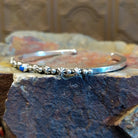 Sterling silver cuff bracelet with starry beadwork along the band and lapis centerpiece set in the round bezel.