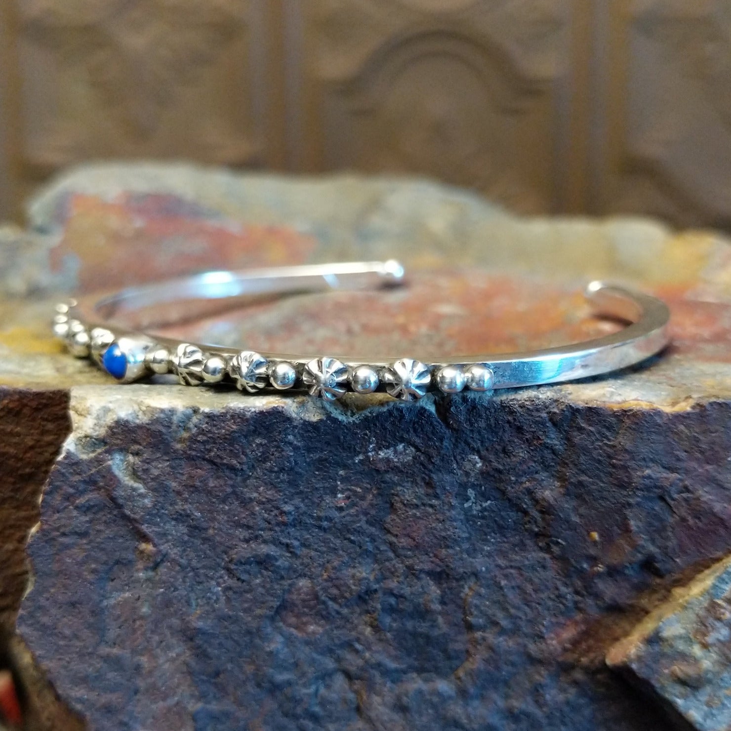 Sterling silver cuff bracelet with starry beadwork along the band and lapis centerpiece set in the round bezel.