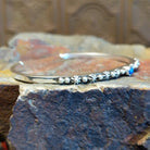 Sterling silver cuff bracelet with starry beadwork along the band and lapis centerpiece set in the round bezel.